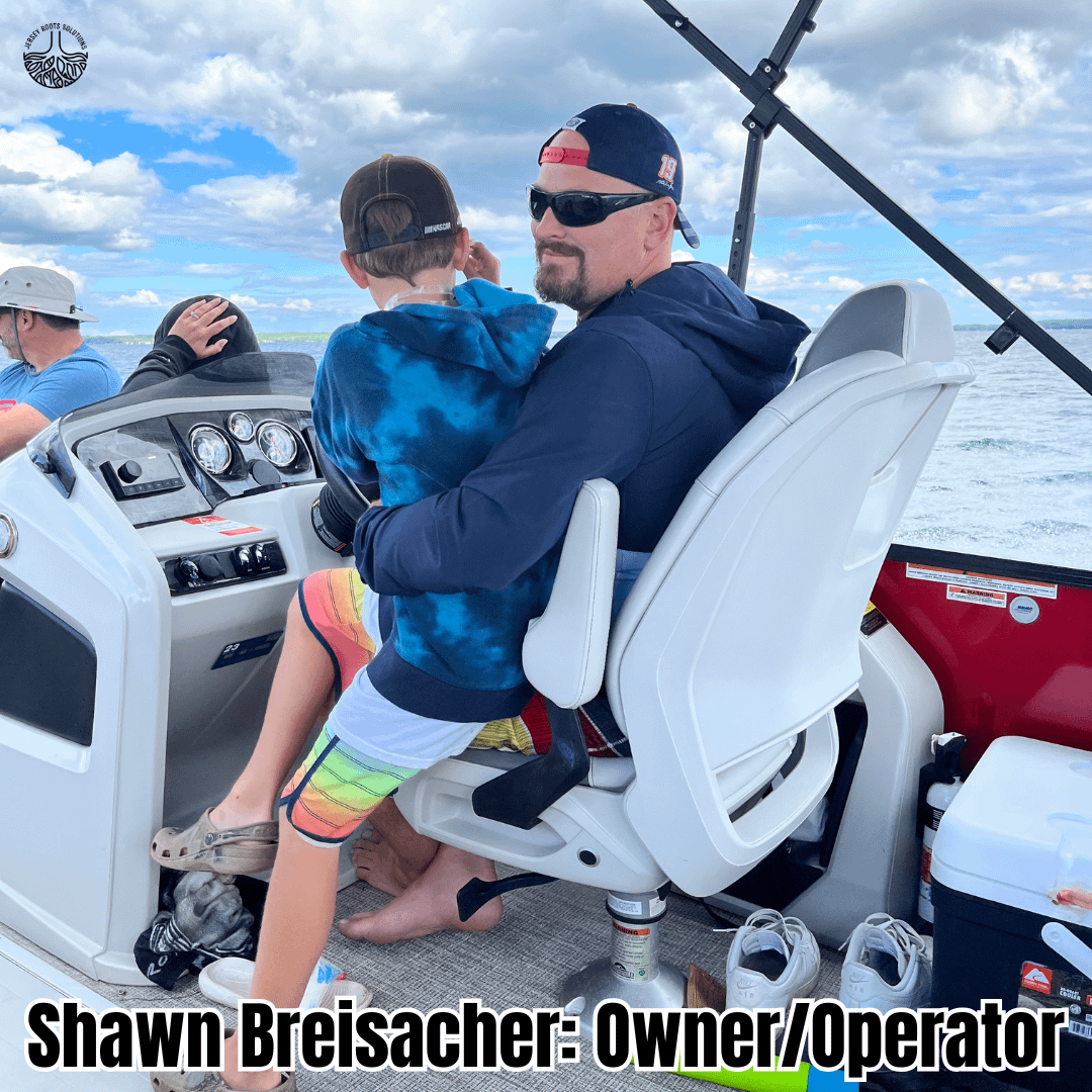 ersey Roots Solutions logo featuring owner Shawn Breisacher, driving pontoon boat on Lake Michigan with child in lap